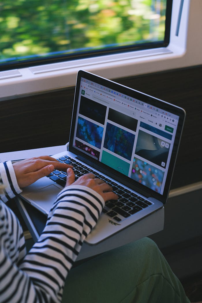 Woman using a laptop on a train, symbolizing digital nomad lifestyle and remote work.