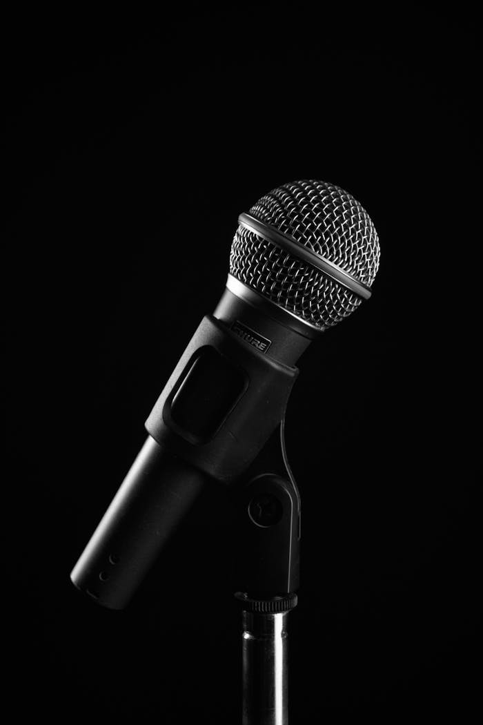 about-04 Studio shot of a microphone on a stand with a black background, ideal for audio and music concepts.